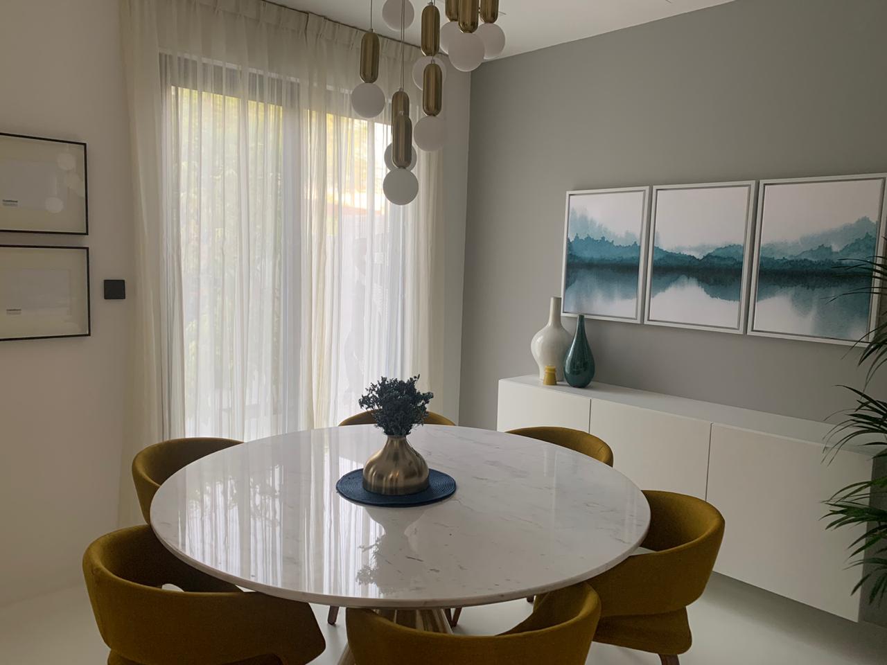 bespoke dining area with marble table, tailored seating, and sheer curtains