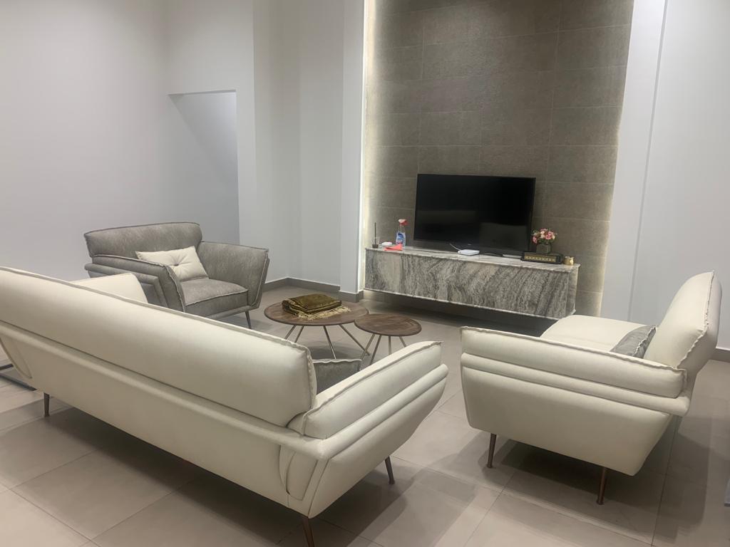 grand living room with custom seating, stone media wall, and full-height curtains